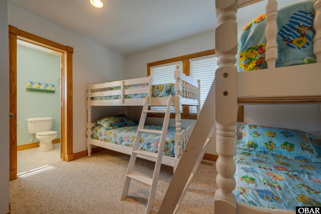 carpeted bedroom with baseboards and ensuite bath