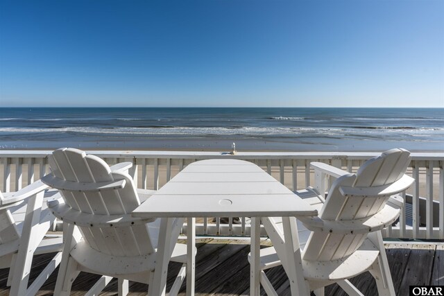 balcony featuring a view of the beach and a water view