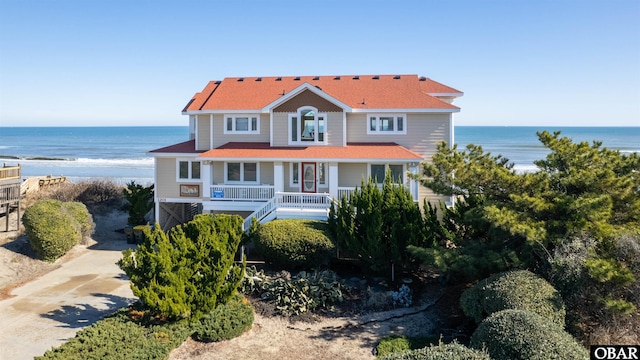 view of front of home featuring a porch, concrete driveway, and a water view