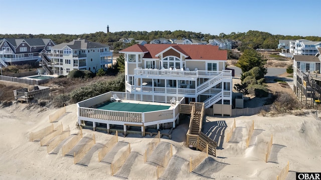 rear view of property featuring stairway, a balcony, and a residential view