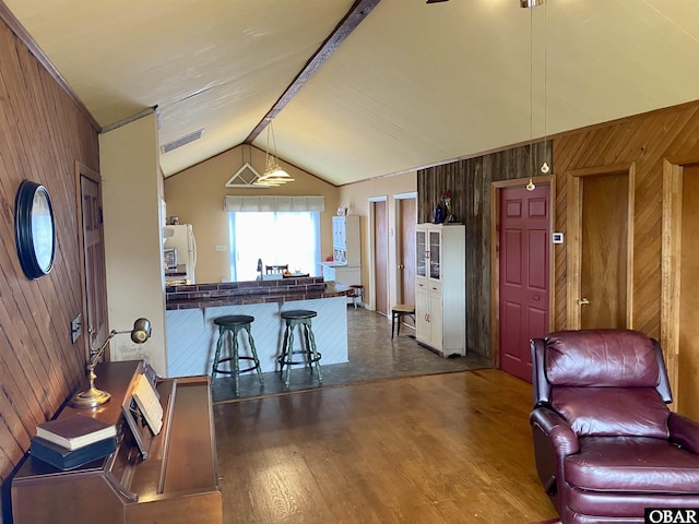 278 Bayview Dr, Stumpy Point, NC 27978 - kitchen with wood walls, dark wood finished floors, lofted ceiling, freestanding refrigerator, and a breakfast bar