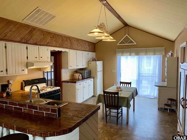 278 Bayview Dr, Stumpy Point, NC 27978 - kitchen featuring white appliances, under cabinet range hood, lofted ceiling, tile counters, and a peninsula