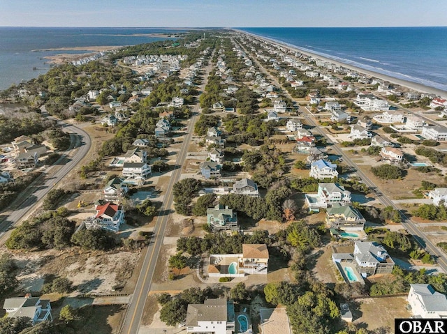 birds eye view of property featuring a water view and a beach view