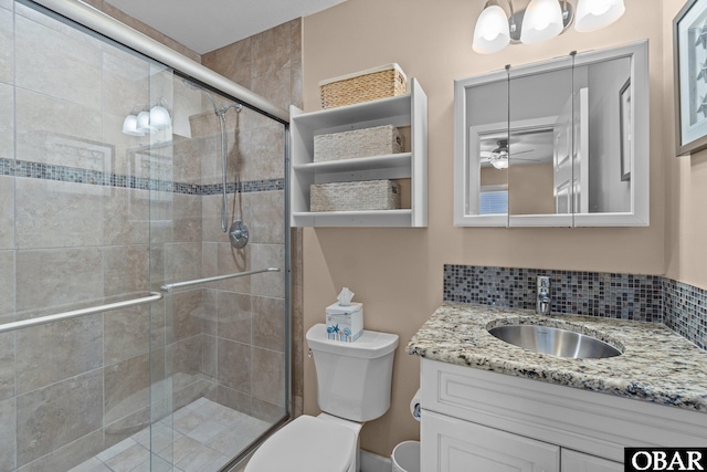 bathroom with decorative backsplash, vanity, toilet, and a shower stall