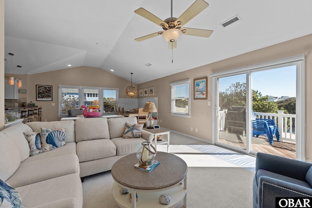 carpeted living room with lofted ceiling, plenty of natural light, and visible vents