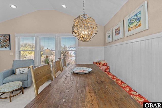 dining room featuring lofted ceiling, wainscoting, a chandelier, and a wealth of natural light