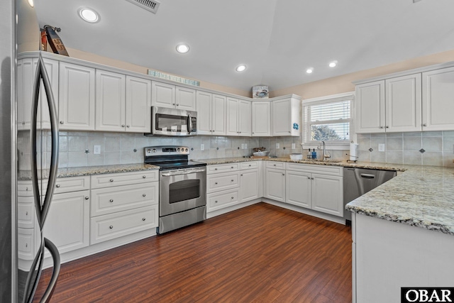 kitchen featuring appliances with stainless steel finishes, dark wood-style flooring, white cabinets, and a sink