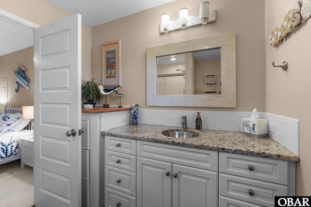 bathroom featuring ensuite bath, tasteful backsplash, and vanity