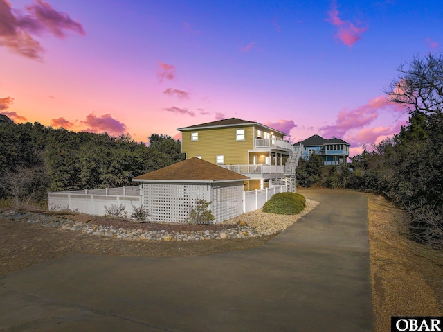 view of front of property with fence and a balcony