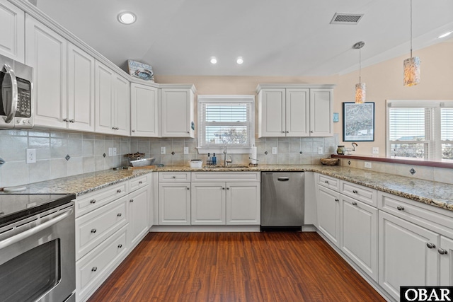 kitchen featuring visible vents, appliances with stainless steel finishes, white cabinets, vaulted ceiling, and a sink