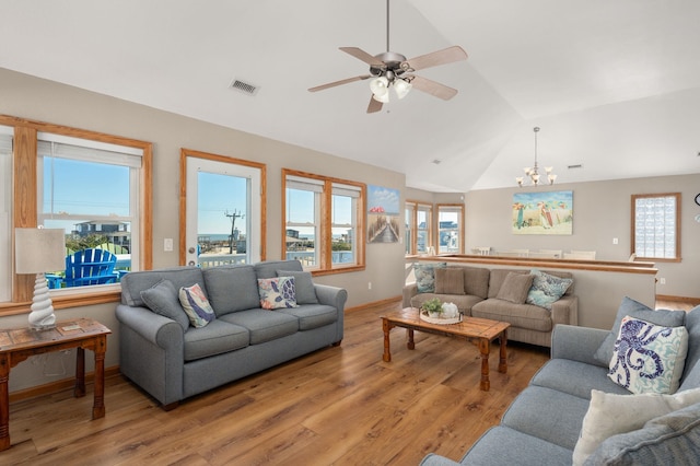 living area featuring vaulted ceiling, light wood finished floors, visible vents, and baseboards