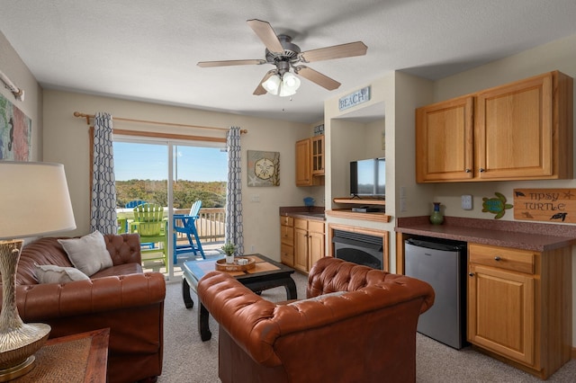 interior space with a textured ceiling, light carpet, and a ceiling fan