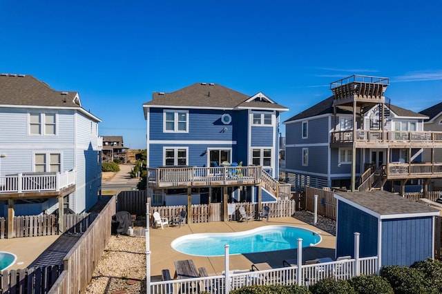 rear view of house featuring a fenced in pool, a residential view, and a fenced backyard