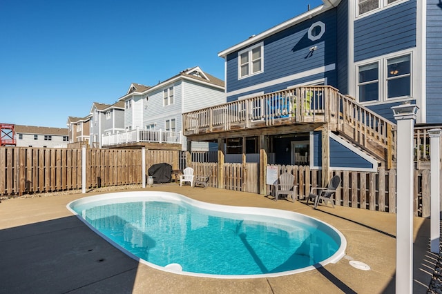 view of pool featuring a fenced in pool, fence, a deck, a residential view, and stairs