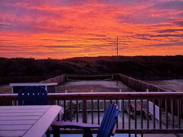 deck at dusk featuring fence