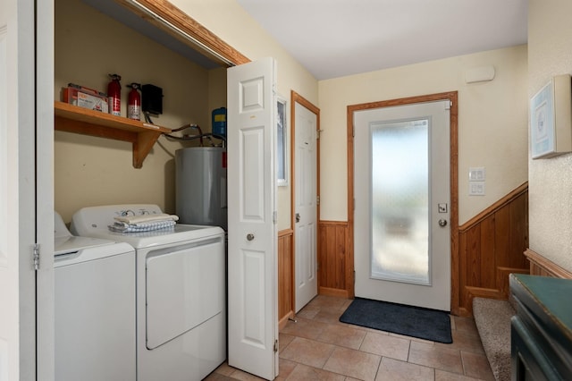 washroom featuring wooden walls, a wainscoted wall, laundry area, water heater, and independent washer and dryer