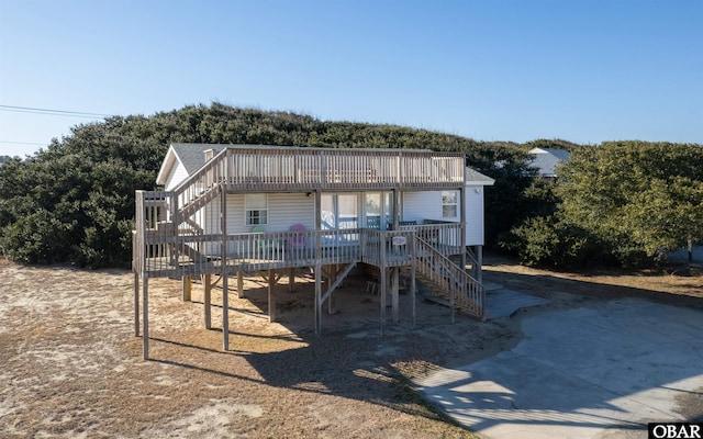 view of front facade with driveway, stairway, and a deck