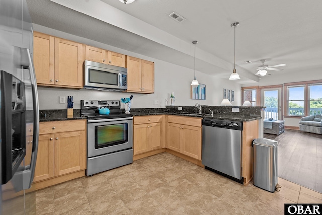 107 W Gray Eagle St Unit 103A, Nags Head, NC 27959 - kitchen with appliances with stainless steel finishes, light brown cabinetry, and a peninsula