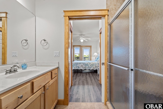 107 W Gray Eagle St Unit 103A, Nags Head, NC 27959 - ensuite bathroom featuring vanity, a stall shower, a ceiling fan, and wood finished floors