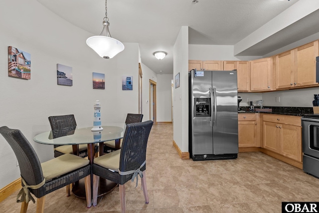107 W Gray Eagle St Unit 103A, Nags Head, NC 27959 - kitchen with stainless steel appliances, light brown cabinetry, and hanging light fixtures