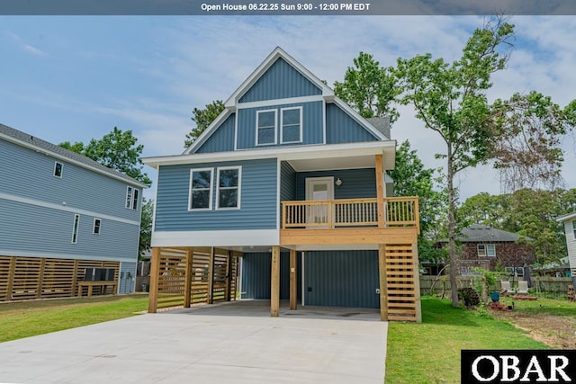 224 W Lost Colony Dr Lot 13, Nags Head, NC 27959 - coastal home with a carport, board and batten siding, concrete driveway, a front lawn, and stairs