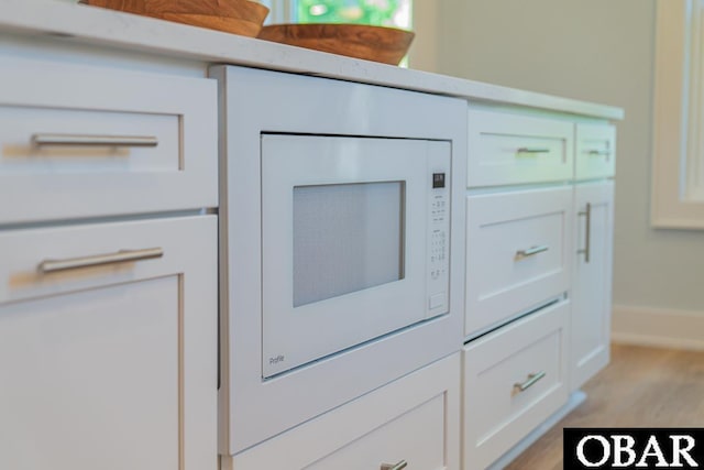 224 W Lost Colony Dr Lot 13, Nags Head, NC 27959 - kitchen view of light wood-style floors, white cabinets, and white microwave