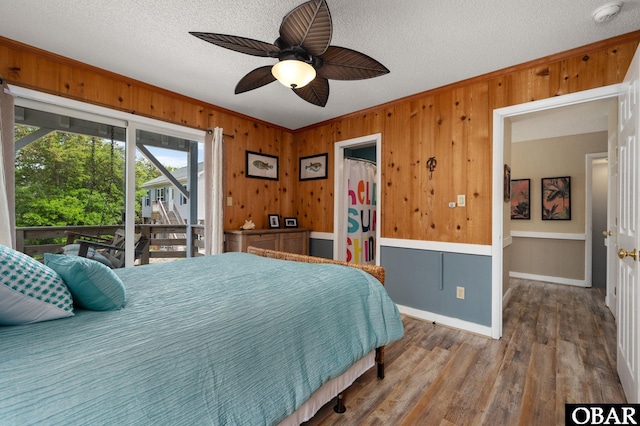 740 E Willet Ct Lot 54, Corolla, NC 27927 - bedroom with ceiling fan, a textured ceiling, wood walls, wood finished floors, and ornamental molding