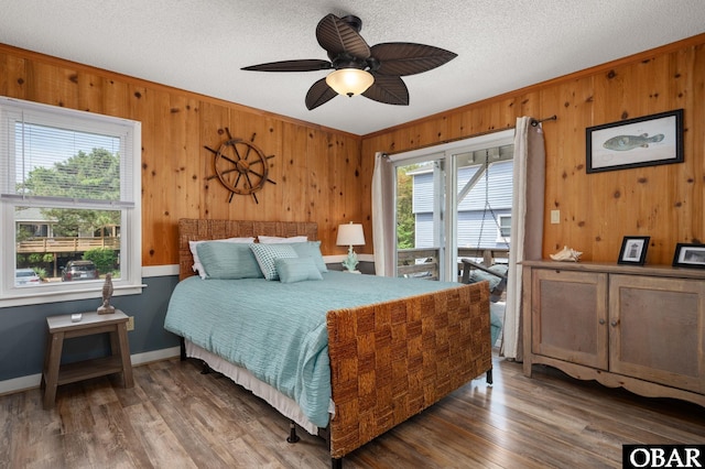 740 E Willet Ct Lot 54, Corolla, NC 27927 - bedroom with wooden walls, multiple windows, wood finished floors, and access to exterior