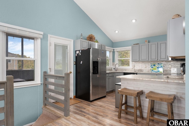 740 E Willet Ct Lot 54, Corolla, NC 27927 - kitchen with vaulted ceiling, gray cabinetry, stainless steel fridge with ice dispenser, a sink, and a peninsula