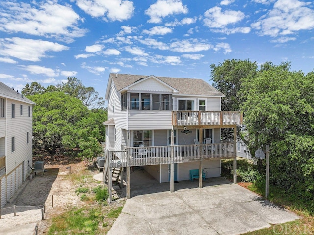 view of front of property with driveway, stairway, roof with shingles, an attached garage, and central air condition unit