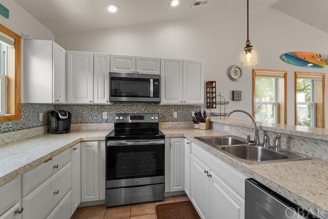 kitchen featuring appliances with stainless steel finishes, light countertops, a sink, and white cabinetry