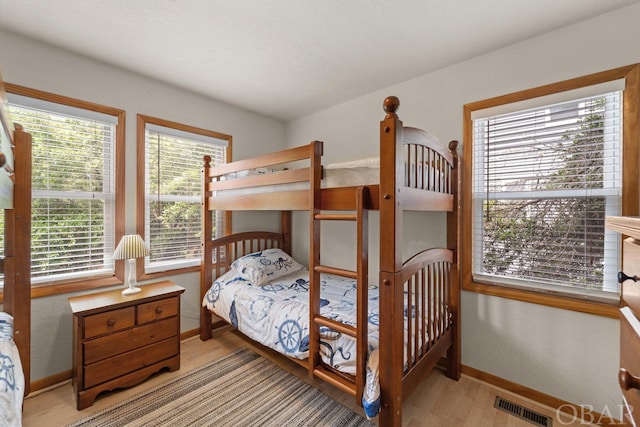 bedroom with light wood-style floors, baseboards, and visible vents