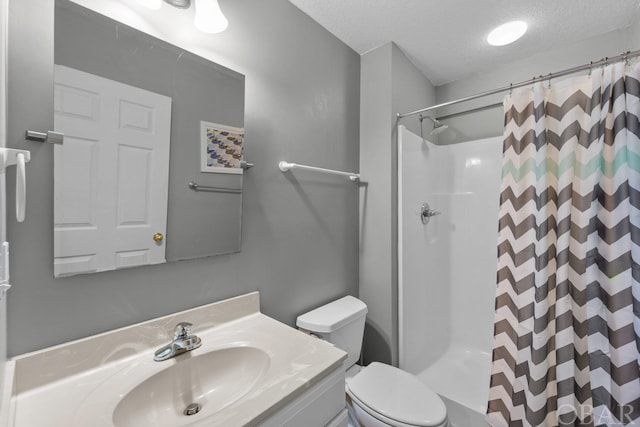 bathroom with toilet, a stall shower, a textured ceiling, and vanity