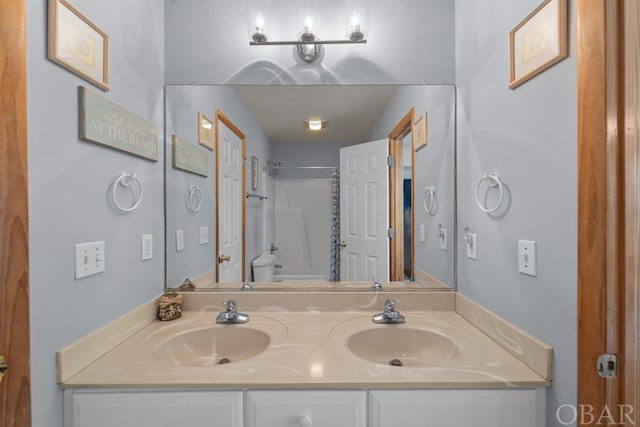 full bath featuring a sink, toilet, and double vanity