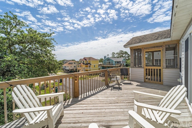 wooden deck featuring a sunroom and a residential view