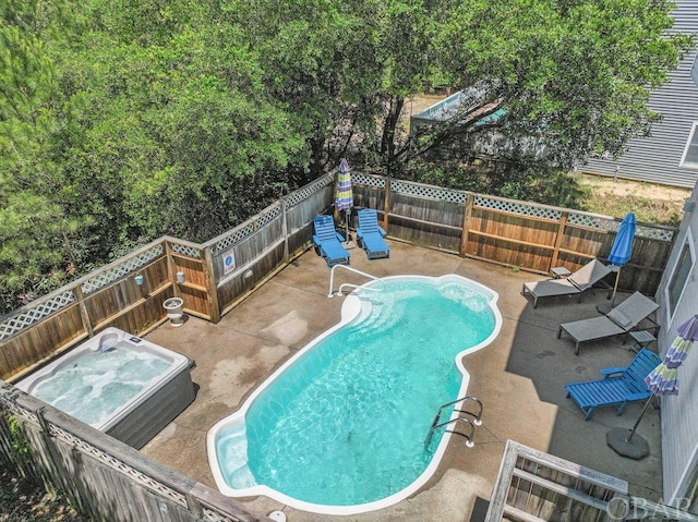 view of swimming pool with a patio, a fenced backyard, and a hot tub