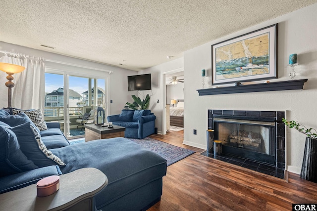 813 Pirates Way Unit 813, Manteo, NC 27954 - living room featuring a textured ceiling, wood finished floors, a fireplace with flush hearth, ceiling fan, and baseboards