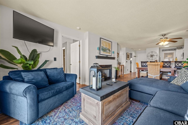 813 Pirates Way Unit 813, Manteo, NC 27954 - living room featuring a ceiling fan, a textured ceiling, a glass covered fireplace, and wood finished floors