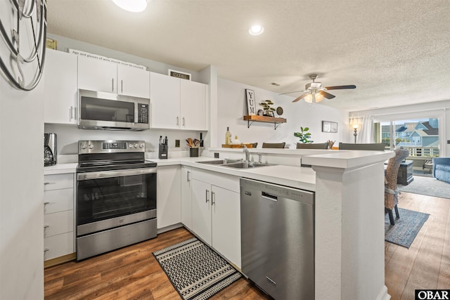 813 Pirates Way Unit 813, Manteo, NC 27954 - kitchen featuring appliances with stainless steel finishes, a peninsula, a ceiling fan, dark wood finished floors, and light countertops
