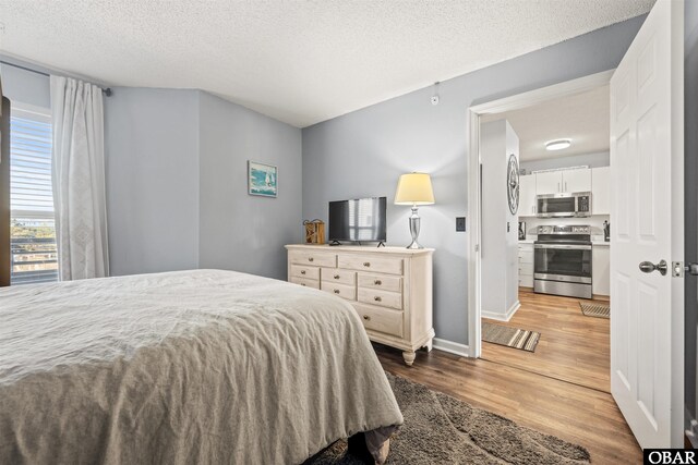 813 Pirates Way Unit 813, Manteo, NC 27954 - bedroom with wood finished floors, a textured ceiling, and baseboards