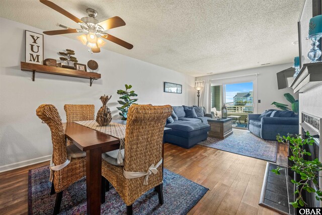 813 Pirates Way Unit 813, Manteo, NC 27954 - dining room featuring wood finished floors, a textured ceiling, ceiling fan, a fireplace, and baseboards