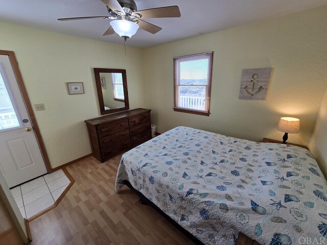 bedroom featuring ceiling fan, light wood-style flooring, and baseboards