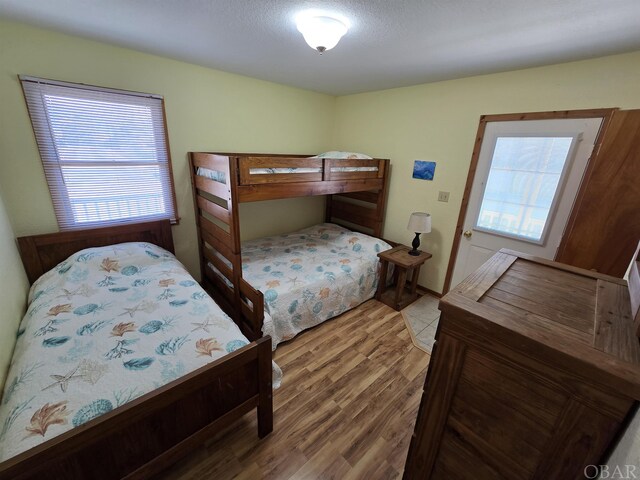 bedroom with multiple windows and wood finished floors