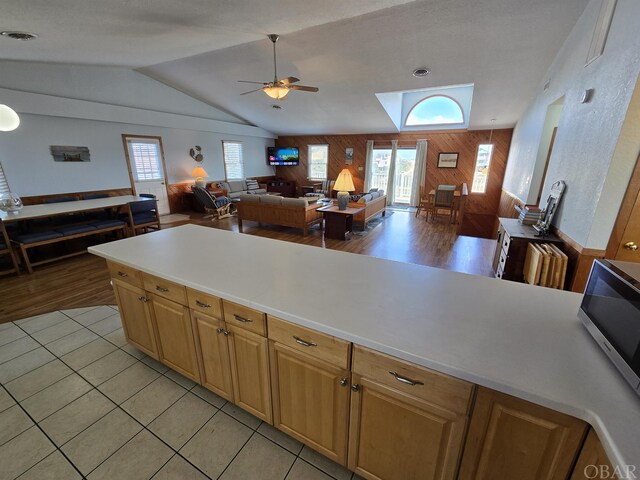 kitchen featuring plenty of natural light, wooden walls, light countertops, and open floor plan