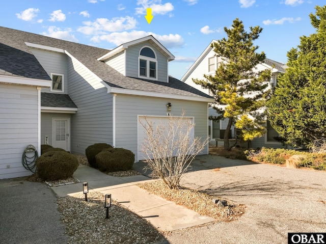 exterior space featuring driveway and a shingled roof