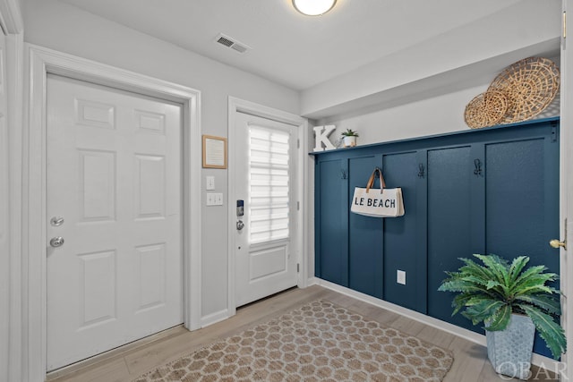 mudroom with baseboards, visible vents, and wood finished floors