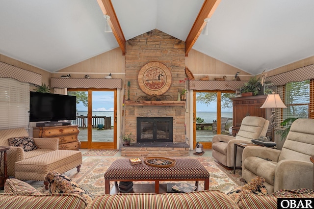 living area featuring beam ceiling, a wealth of natural light, high vaulted ceiling, and a fireplace
