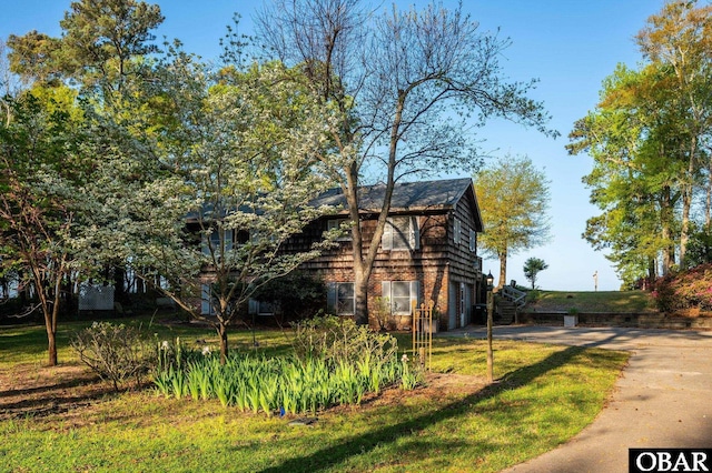 view of side of home featuring an attached garage and a yard