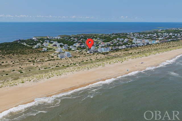 drone / aerial view featuring a water view and a beach view