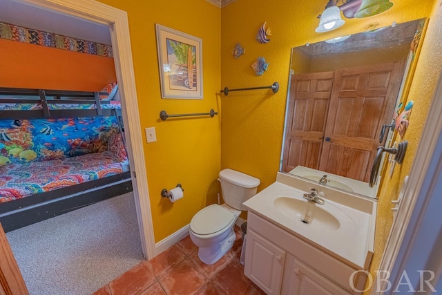 bathroom with toilet, vanity, ensuite bath, tile patterned flooring, and baseboards